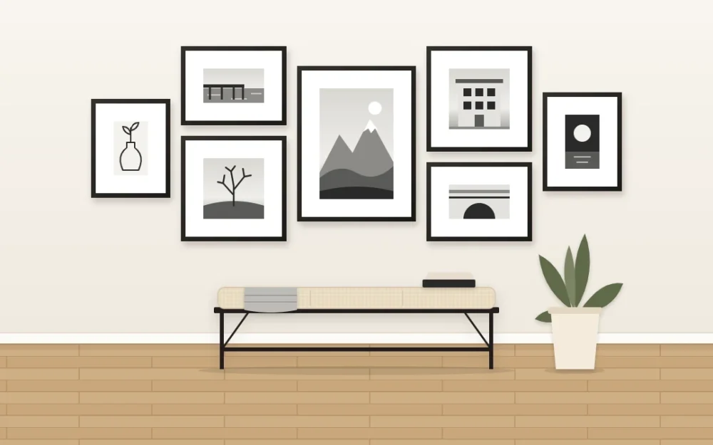 White wall with seven black frames and wide white mats holding grayscale scenes and a line drawing above a black bench