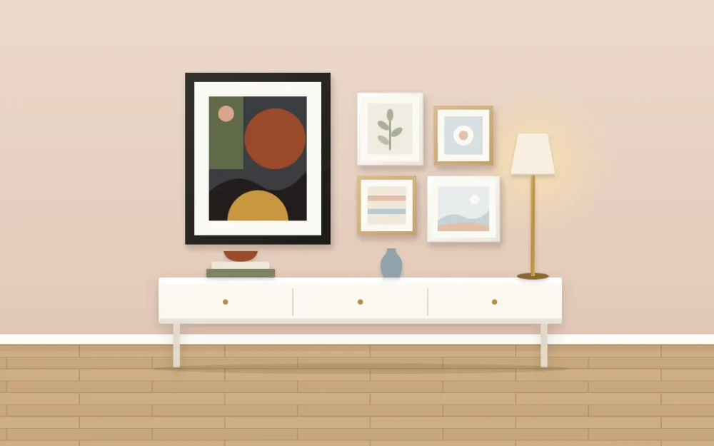 Asymmetrical gallery wall above a console with one large dark-framed abstract on the left balanced by four small light frames and a tall lamp on the right